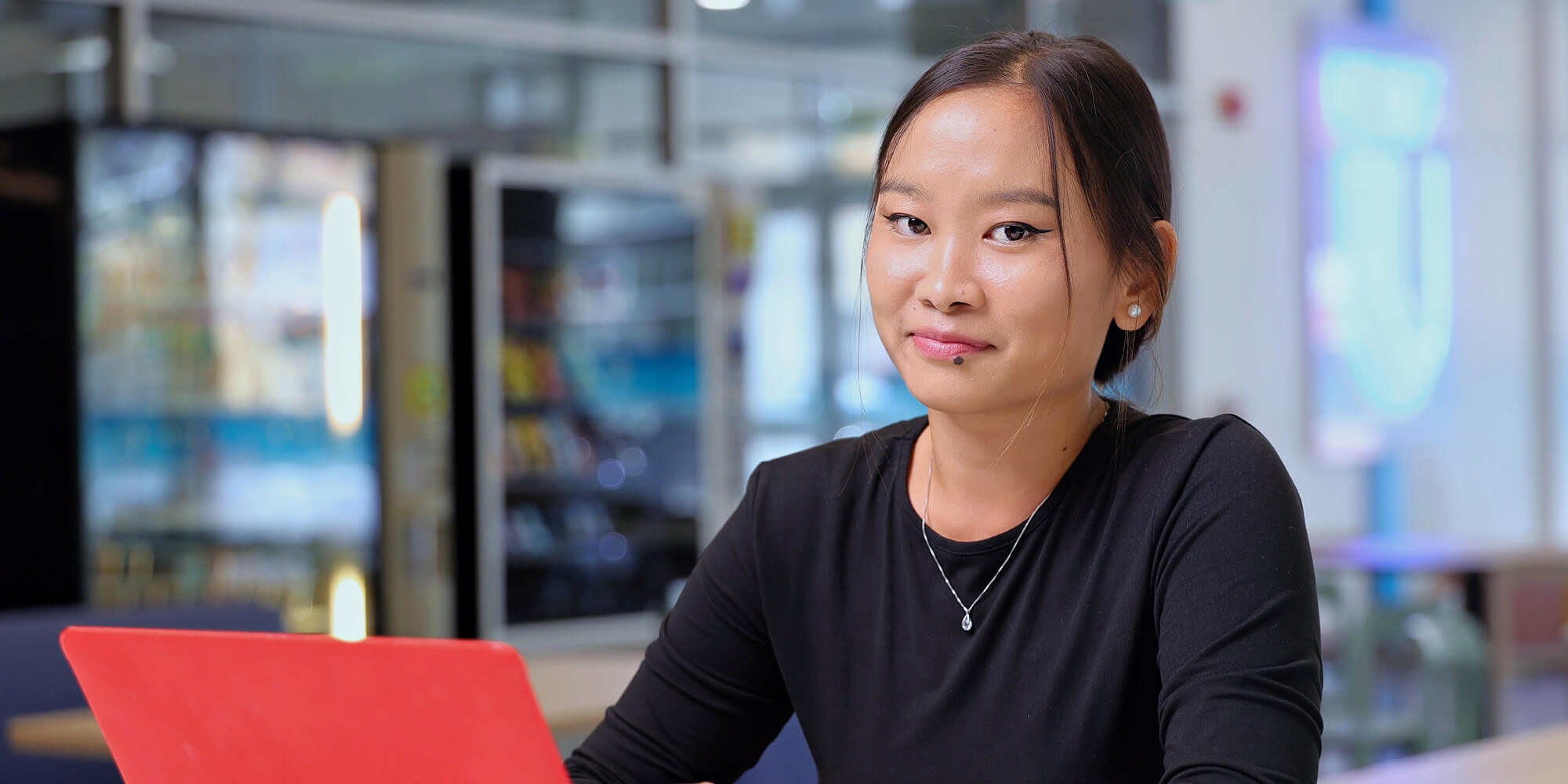 A woman with a laptop smiling for the camera