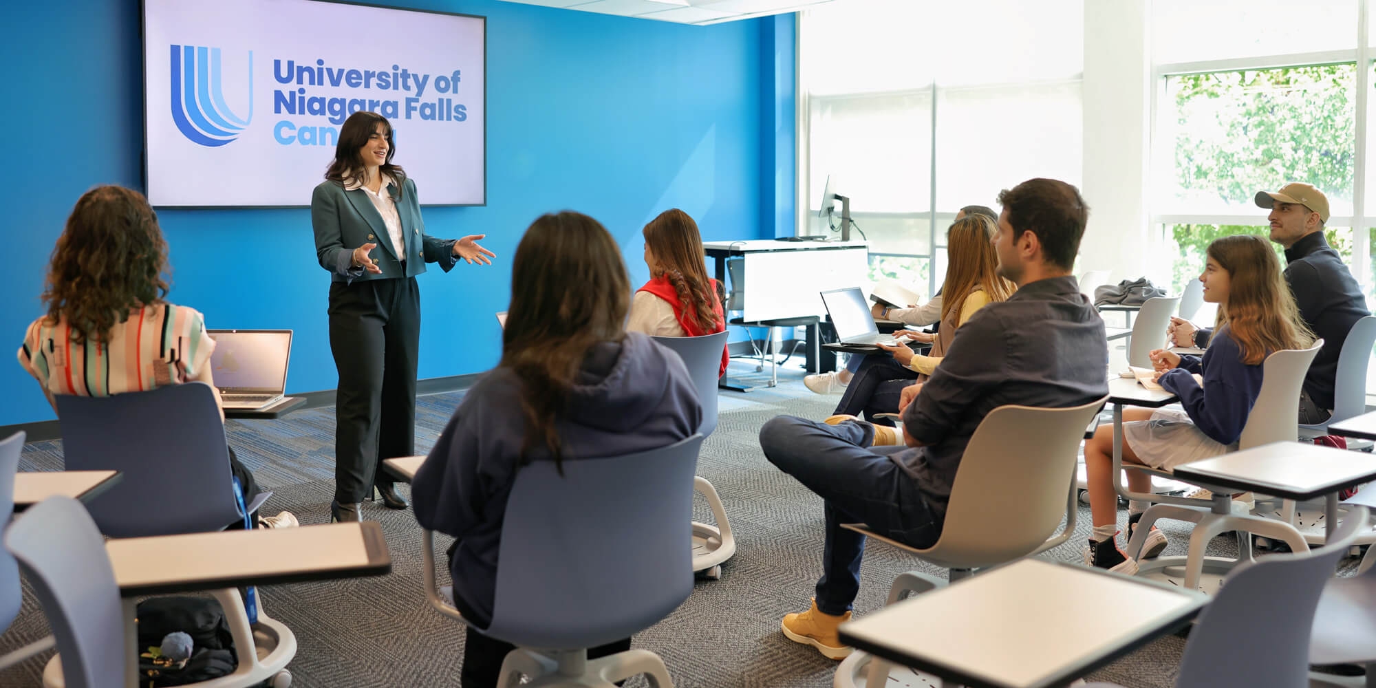 A woman delivers a presentation to a captivated audience, showcasing visual aids in a professional setting