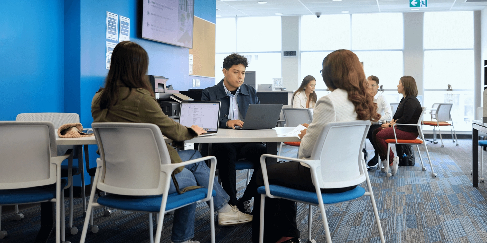 A group of students with laptops studying inside UNF campus