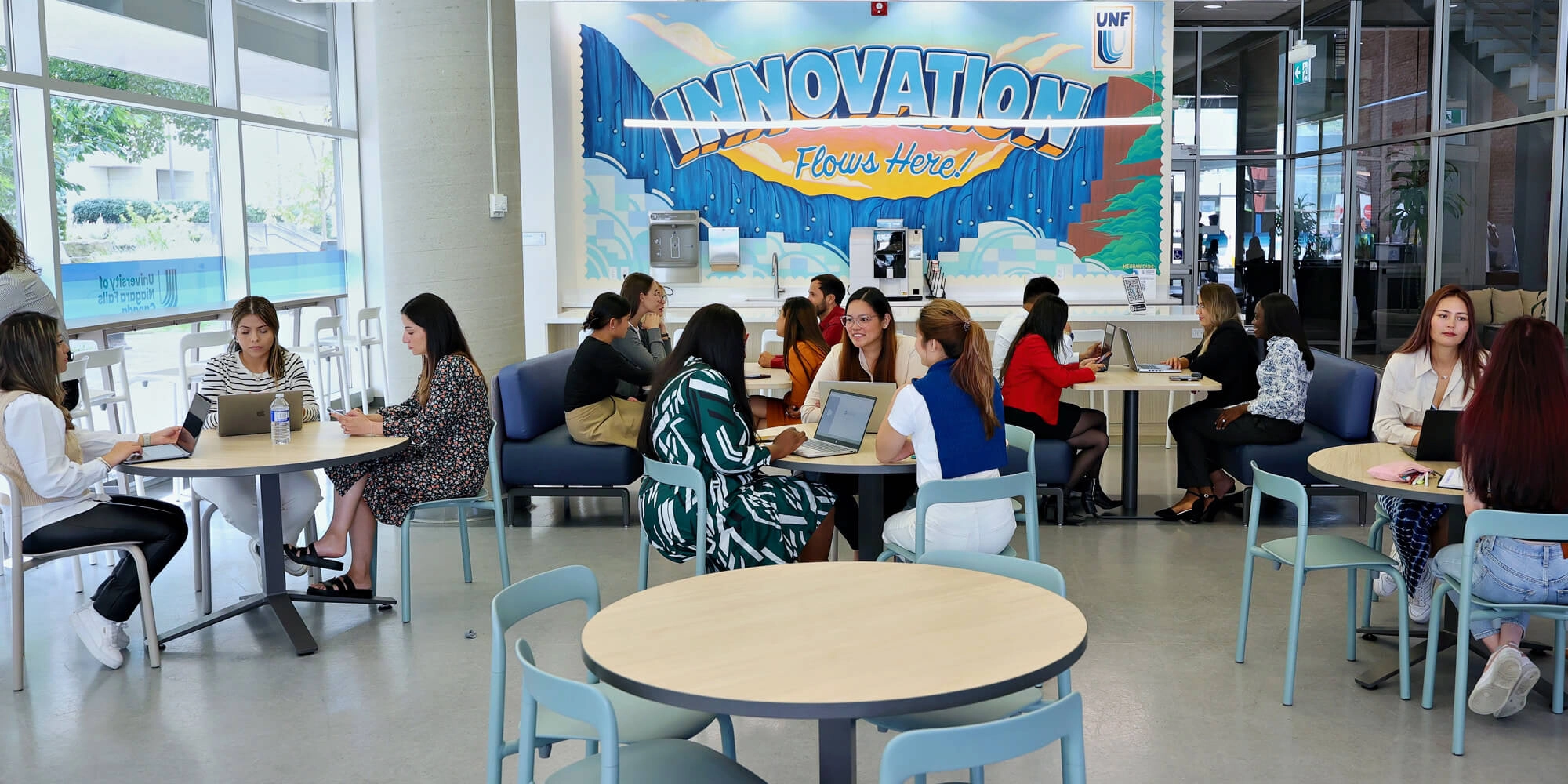 A group of individuals with laptops studying in a common area inside UNFC campus