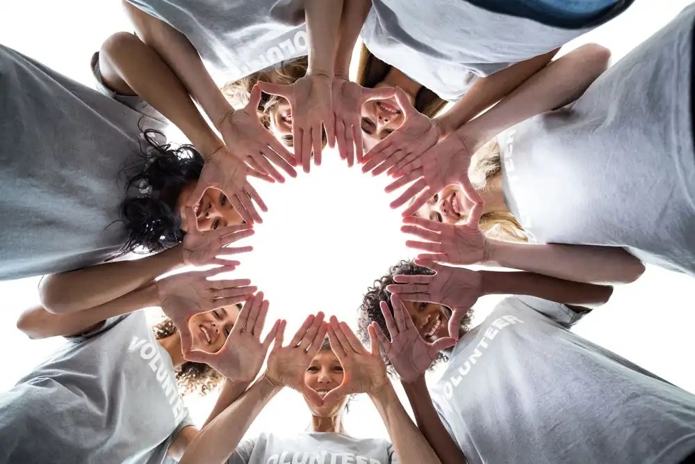 volunteers joining hands and picture was taken from bottom angle