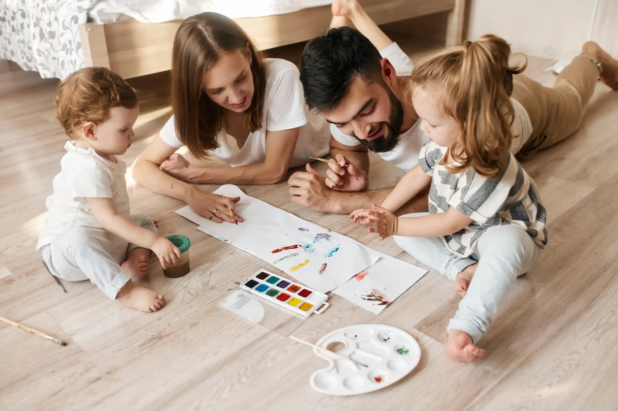 Family of four colouring and painting on papers
