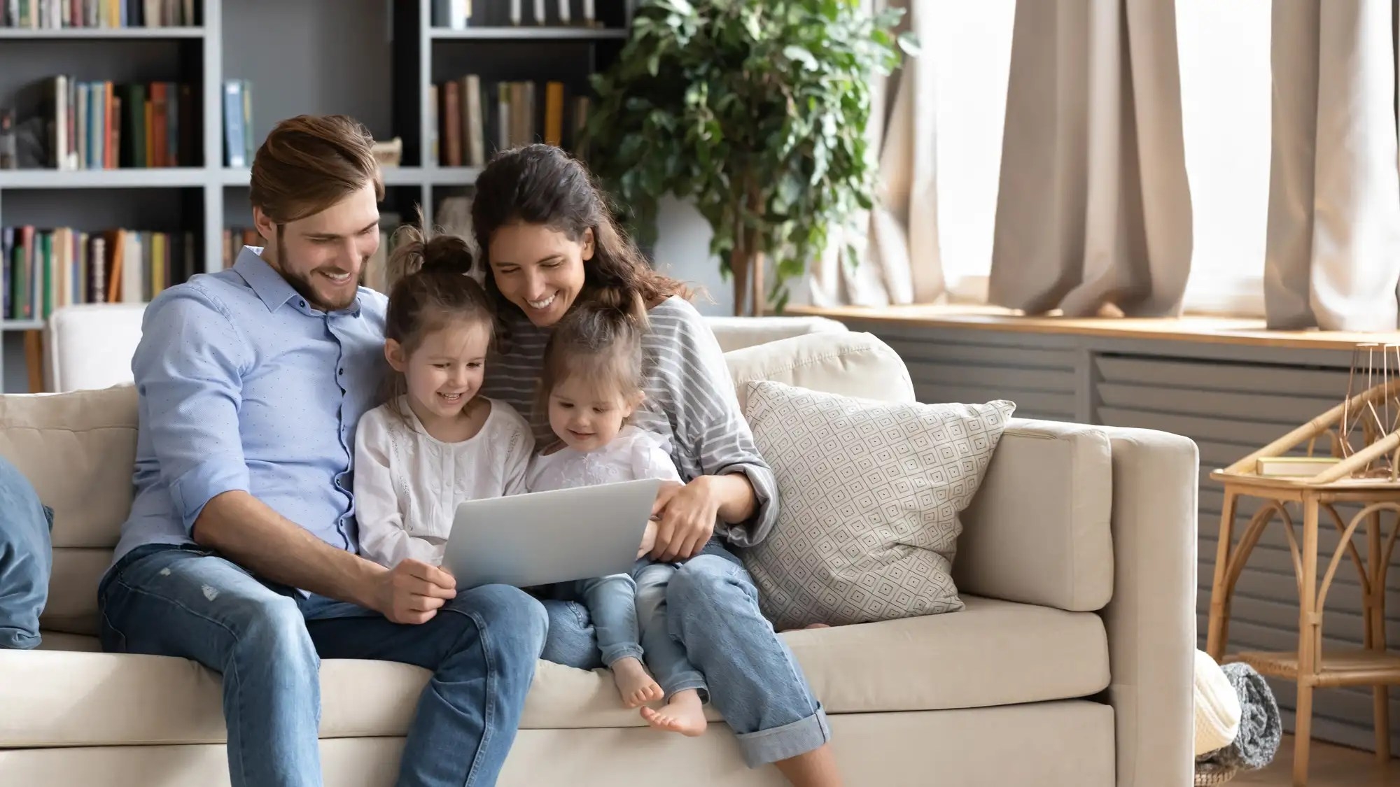 A family looking at a laptop screen and smiling