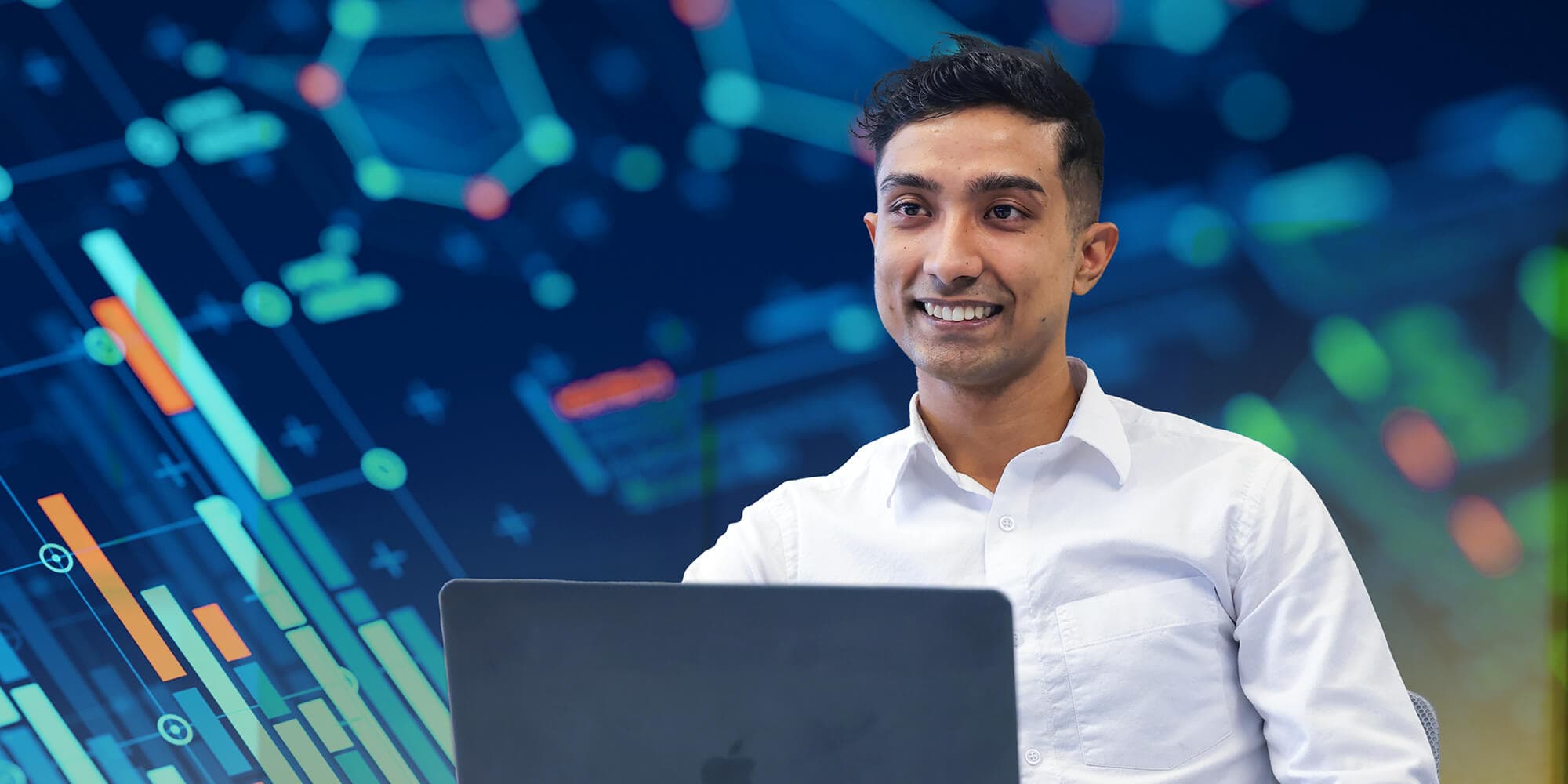 A male student in front of a laptop engagely talking to someone