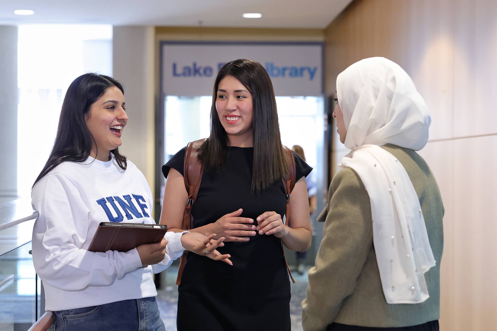 A group of diversed individuals having a conversation in front of UNF library
