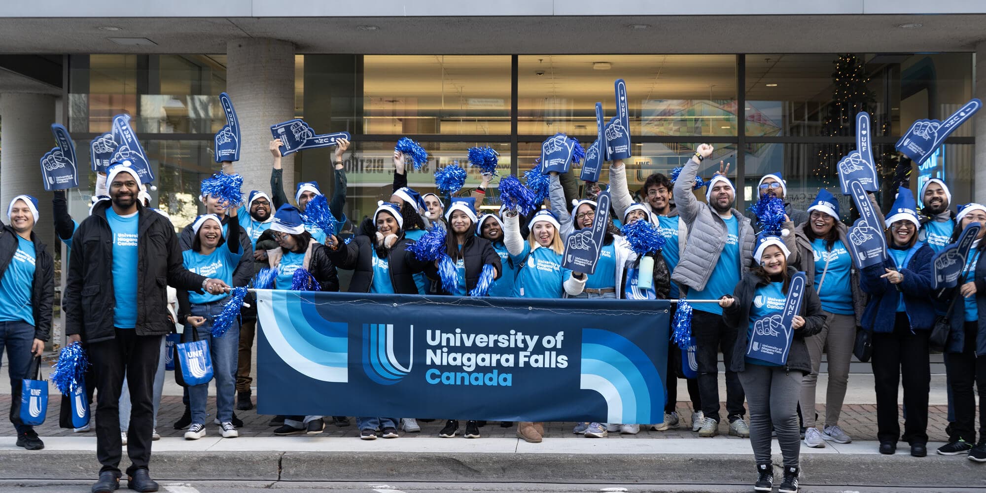 A diverse group of individuals wearing blue shirts and blue hats, gathered together in a cheerful setting