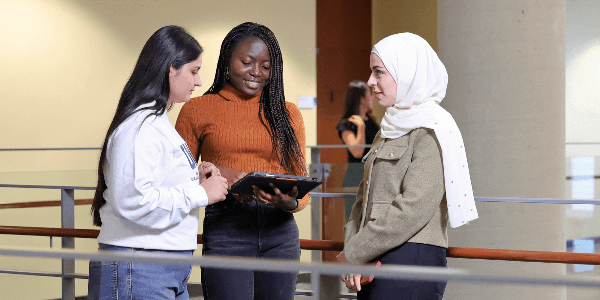 Three female students talking inside UNF campus