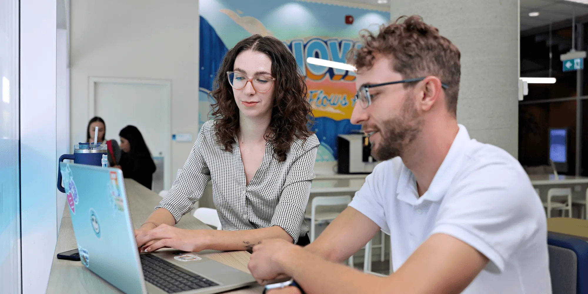 Two students looking at a laptop inside UNF campus