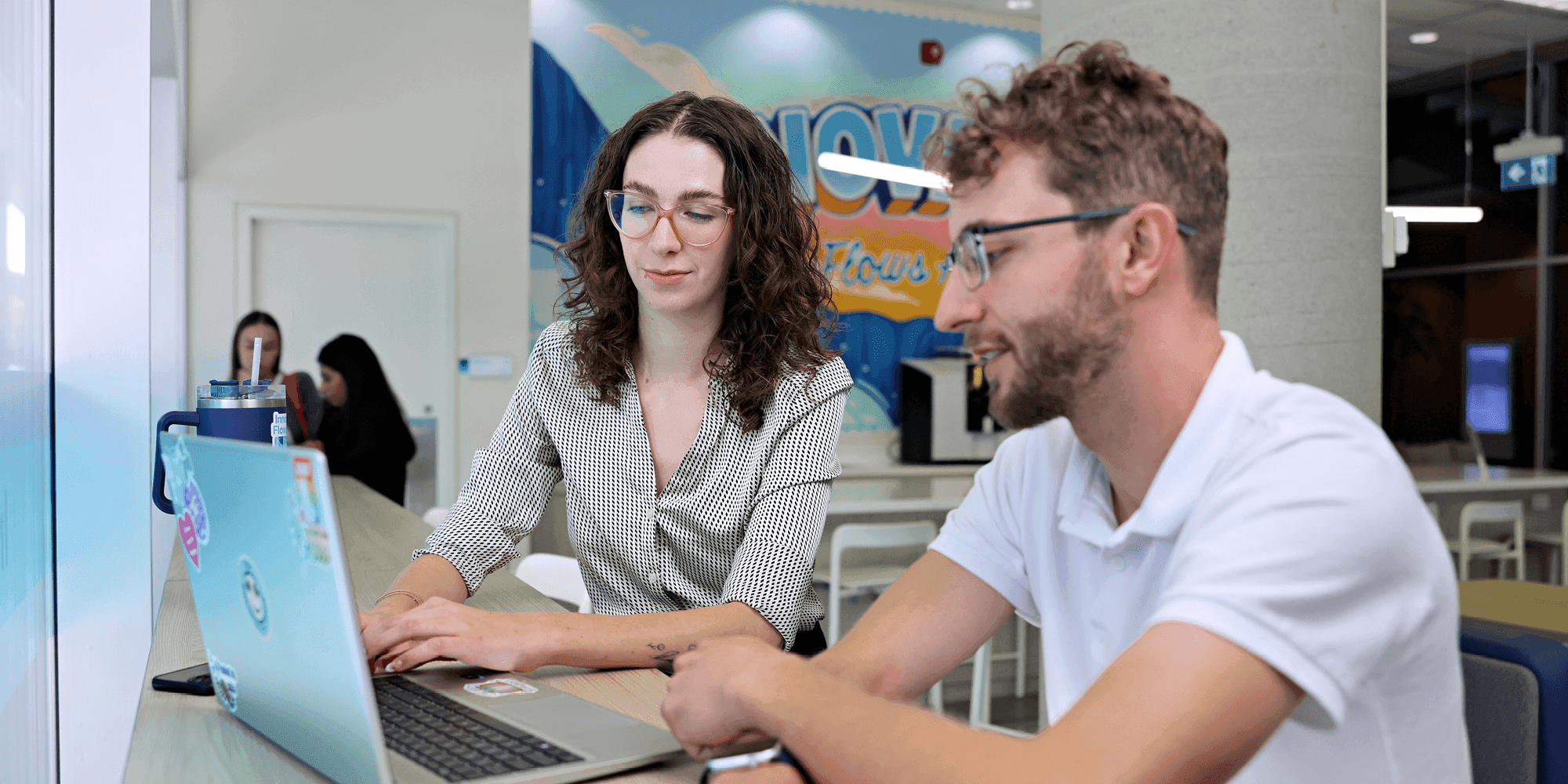 Two students looking at a laptop inside UNF campus