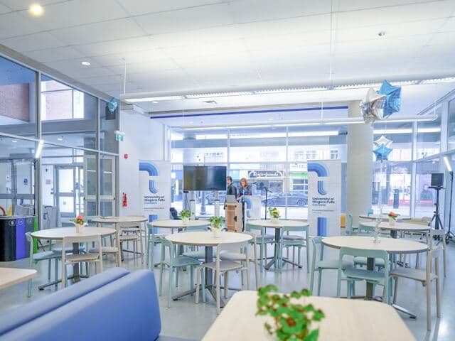 An organized study room with white tables and chairs, creating a clean and inviting space for students to learn