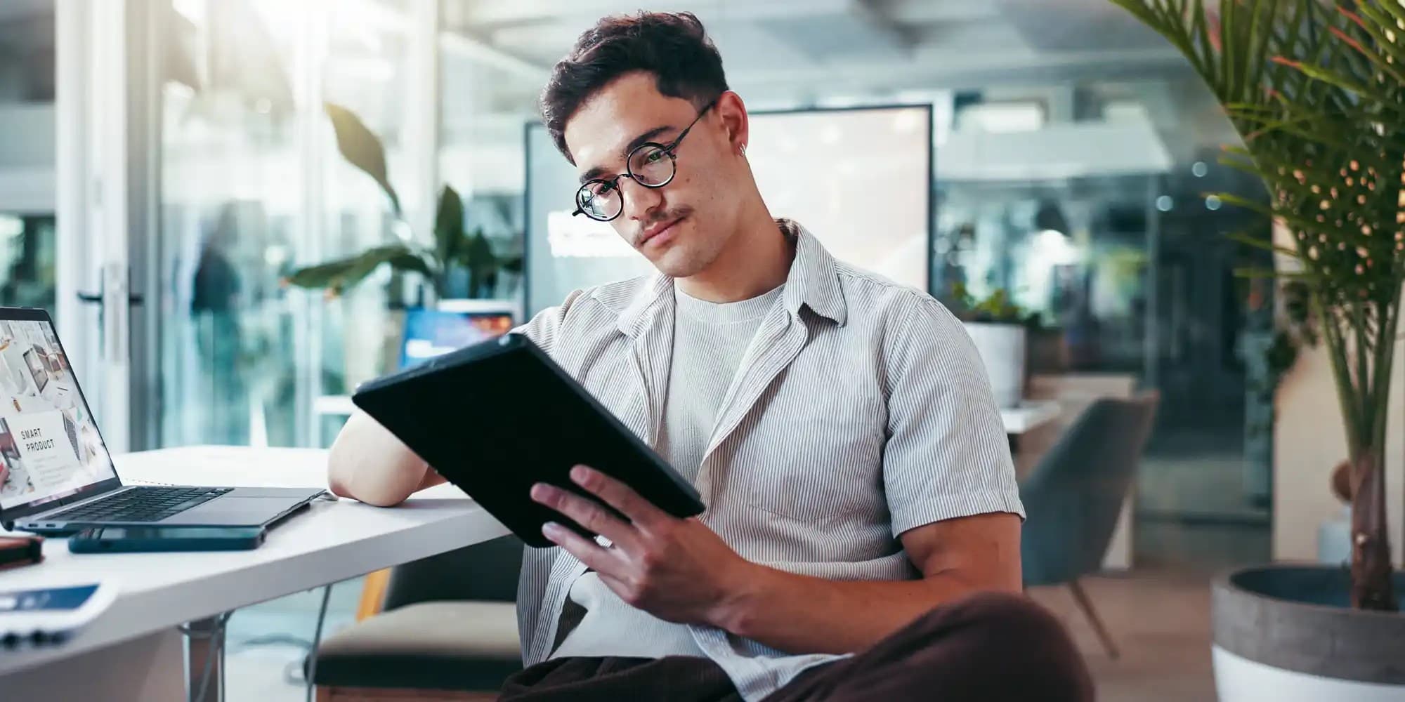 a male looking at a tablet screen