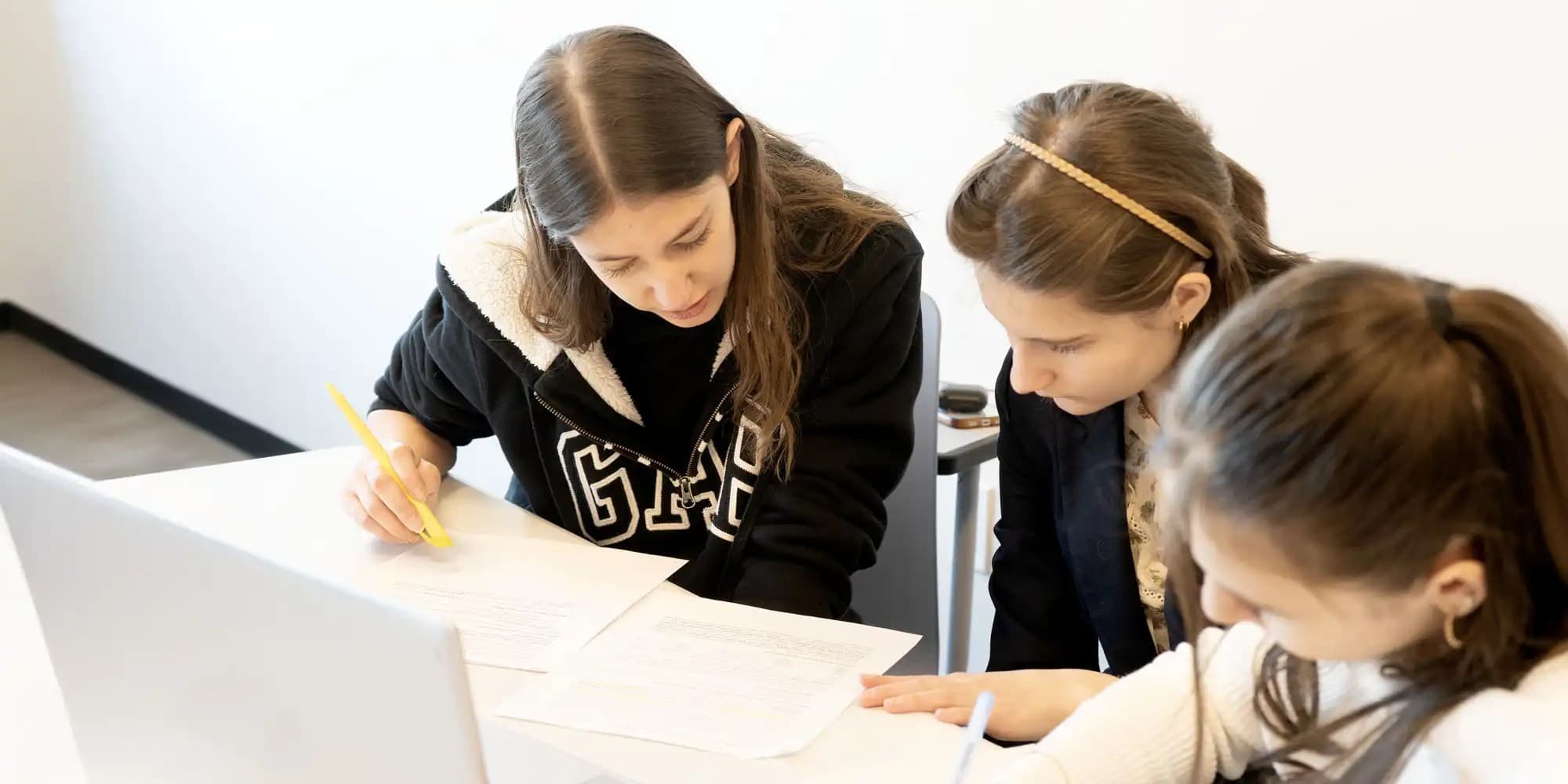 UNF students looking at papers and laptop screen