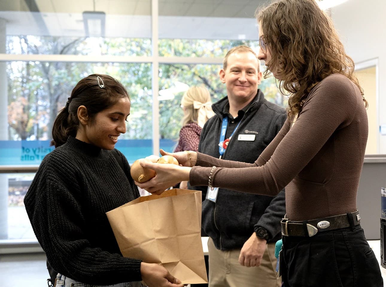 A women giving out grocery items to UNF student