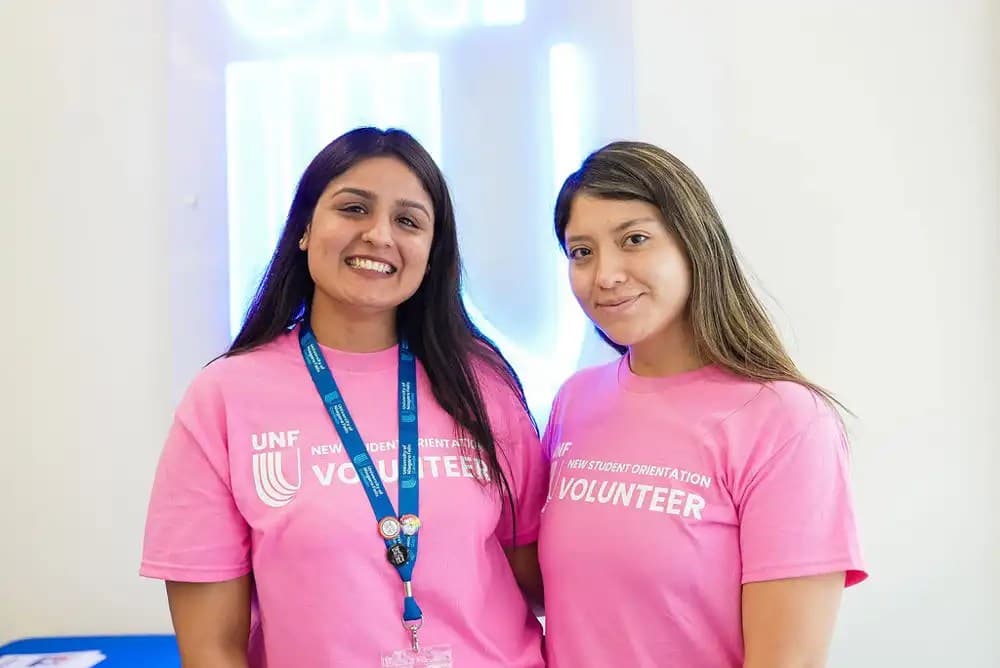 two UNF volunteer smiling at the camera