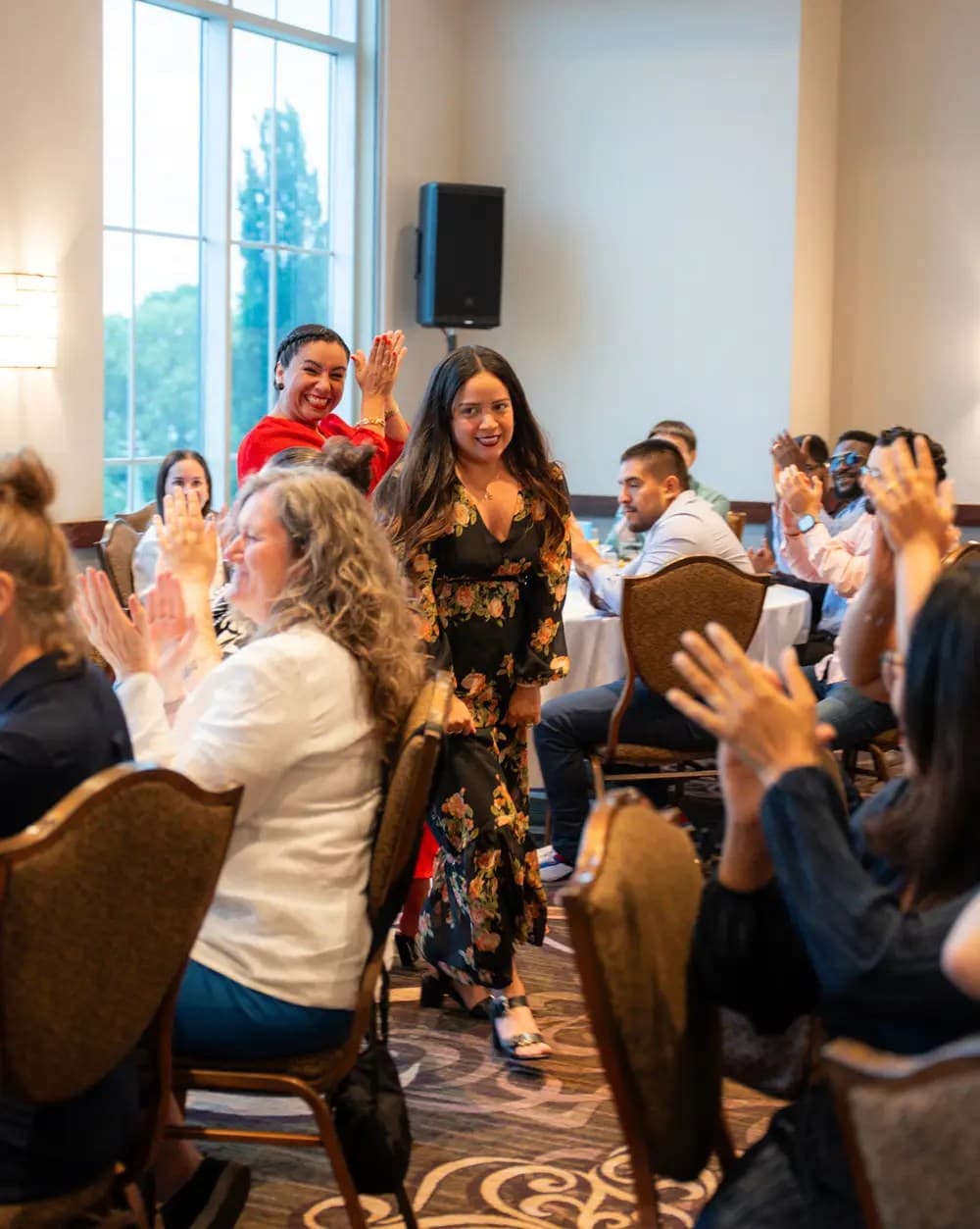 A women walking toward the stage while others claping