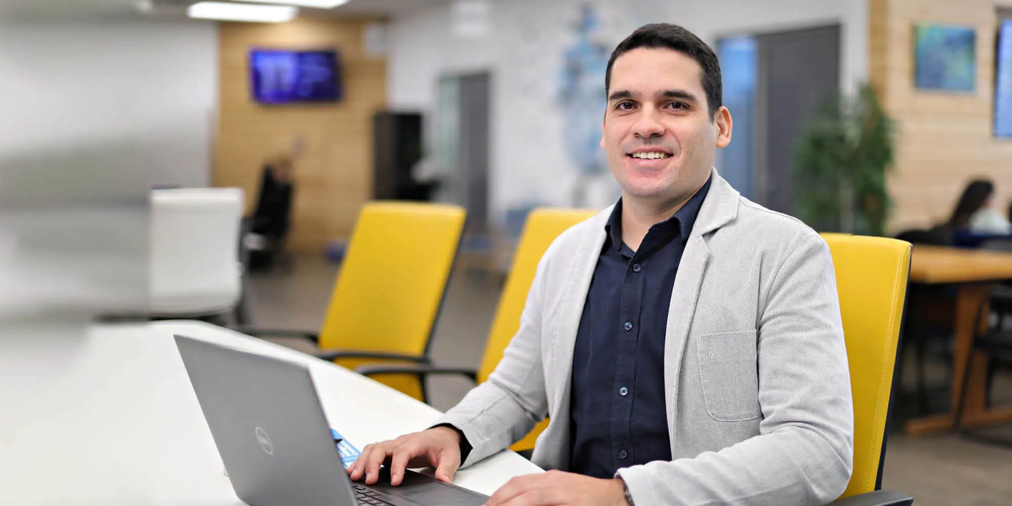 A UNF student studying on a laptop and looking at the camera
