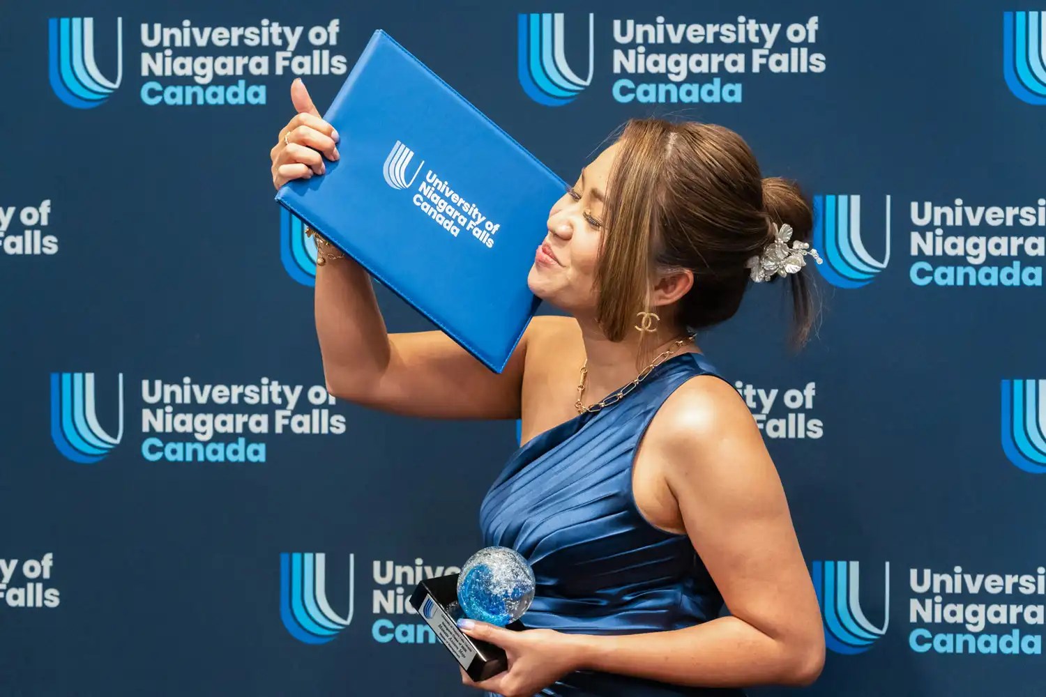 A UNF graduate holding her award an certificate