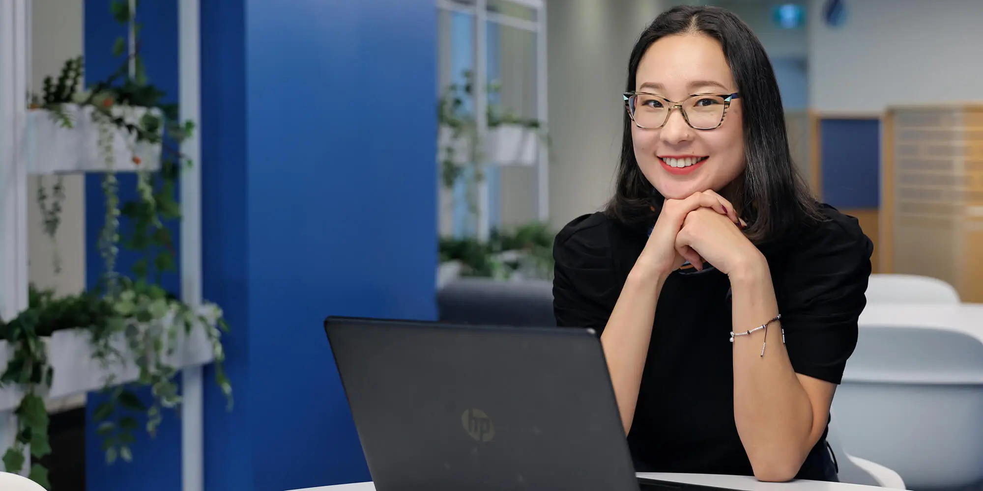 A woman with a laptop smiling for the camera