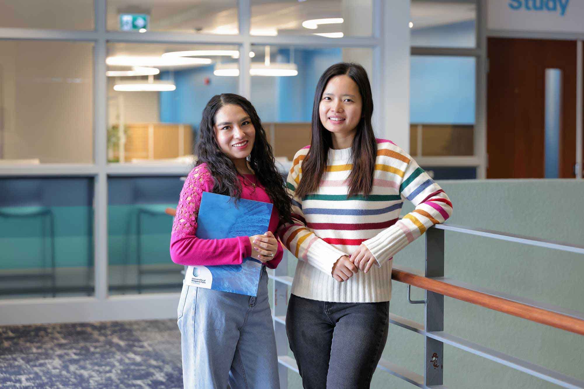 Two UNF students posing for a picture inside the campus building