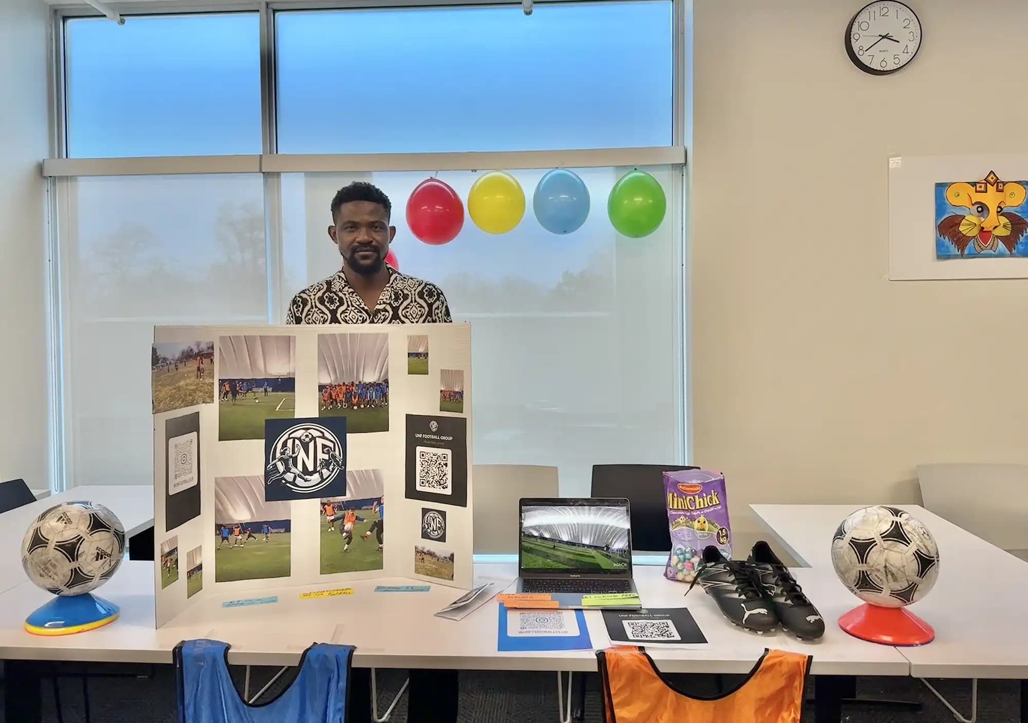 A UNF student from football club holding a presentation board
