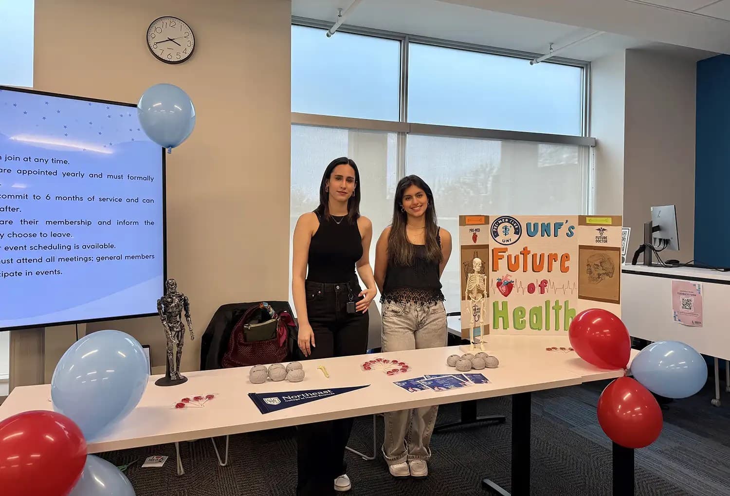 Two female students standing at the mental health association booth