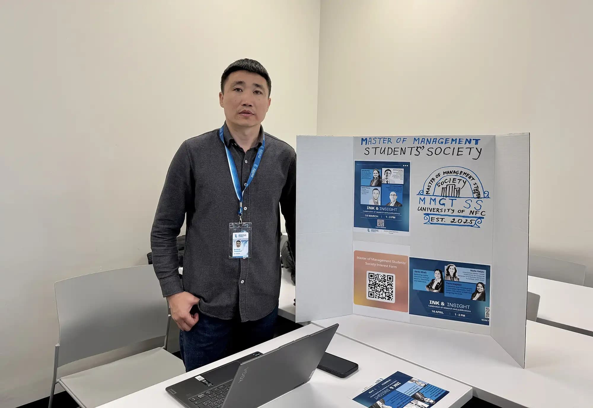 A UNF student from Master of Management Students Society holding a presentation board