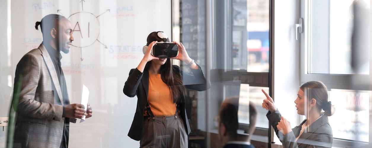 A woman looking through a VR headset while others having a discussion