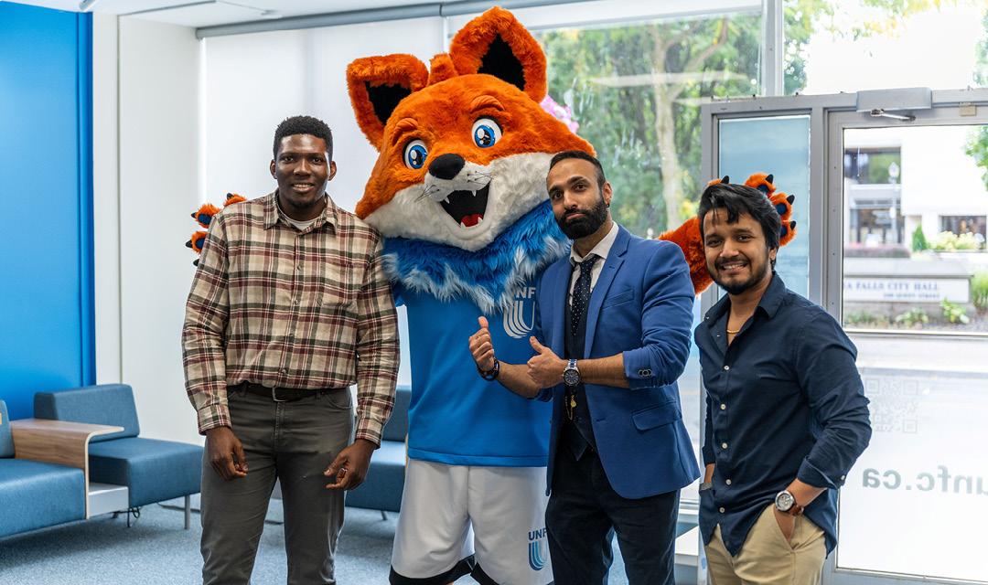 Spark posing for a picture with a UNF staff and students