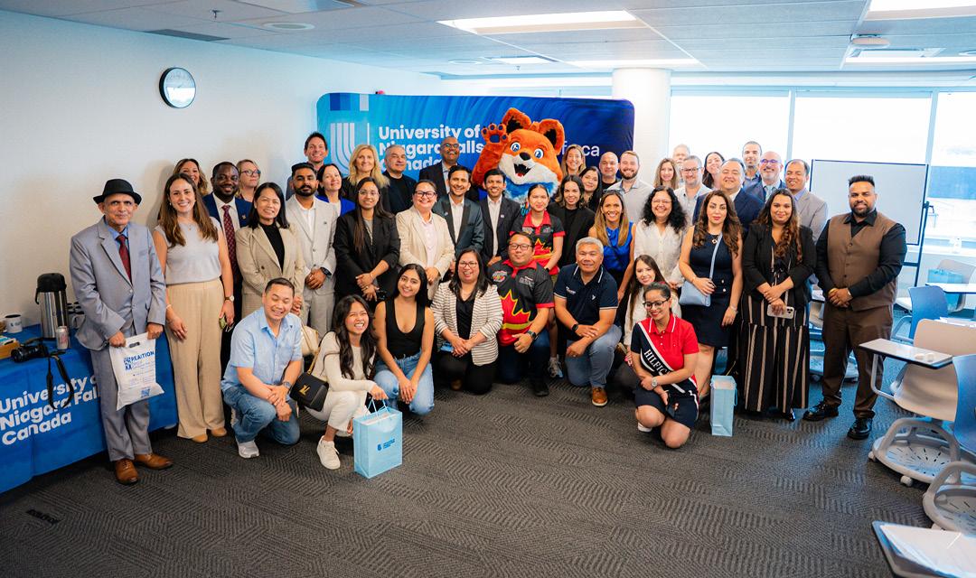 Spark posing for a picture with a UNF staff and students