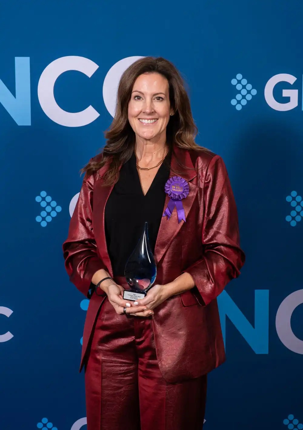 Melanie Sodka posing for a picture with the an award trophy