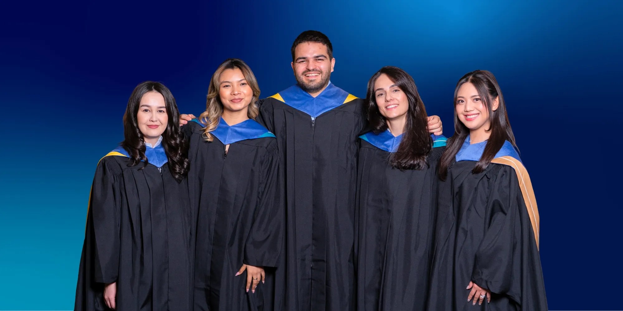 UNF graduates wearing graduation gown and posing for a photo