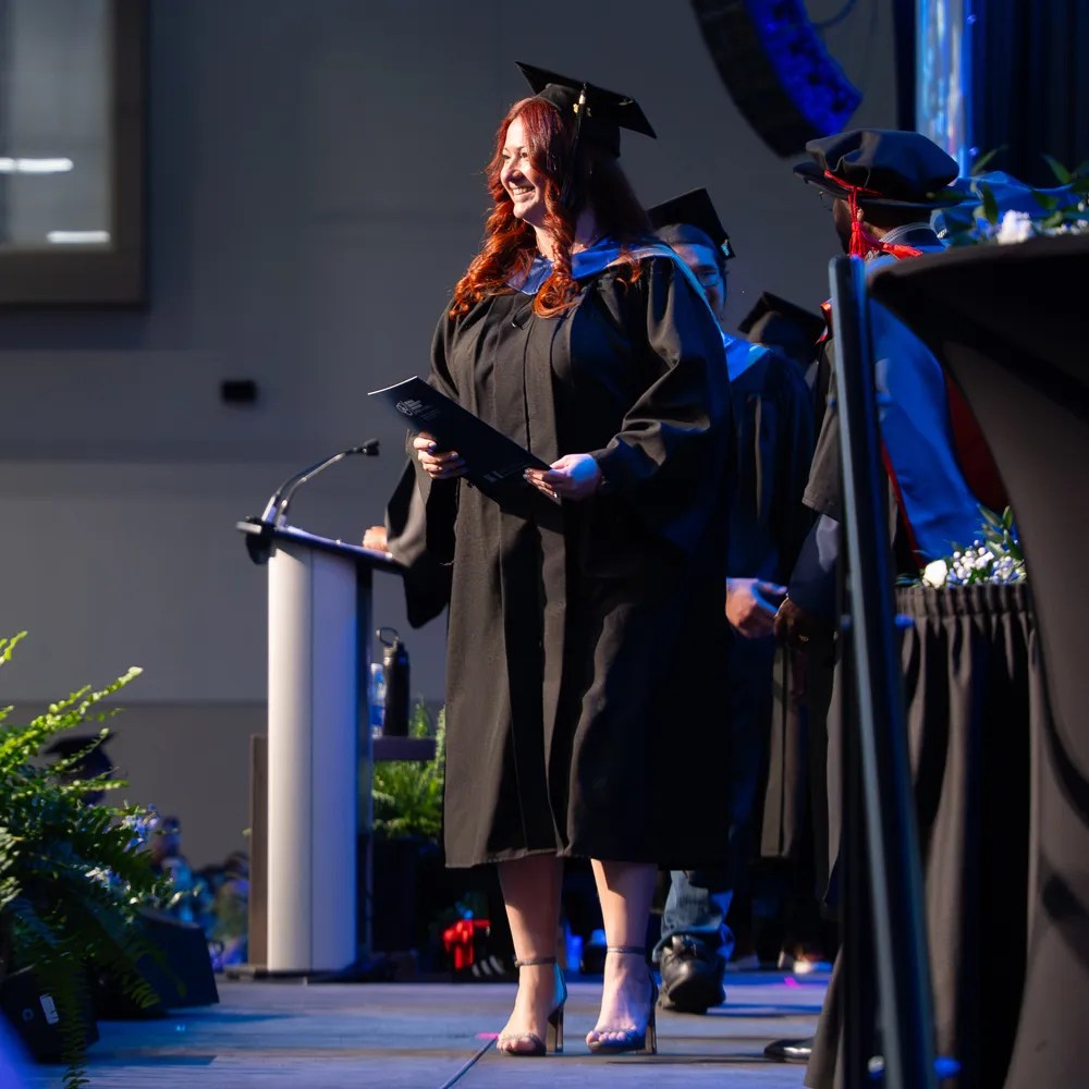 A graduate received her degree and walking across the stage